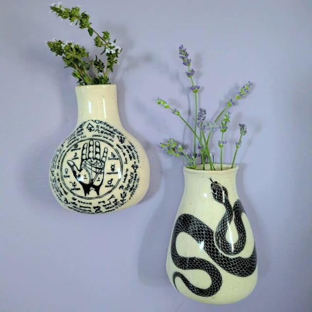 Two hanging wall vases painted with a palmistry hand and a snake